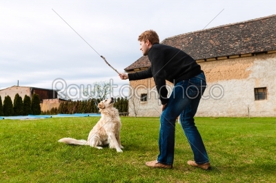 Young man playing with his dog in garden