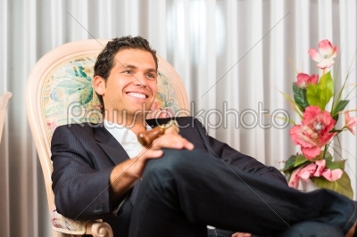 Young man sitting on chair in hotel room
