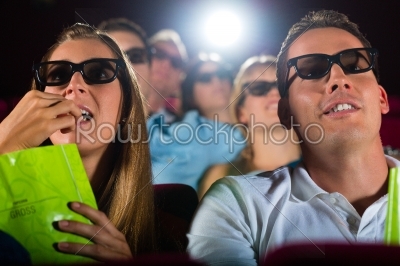 young people watching 3d movie at movie theater