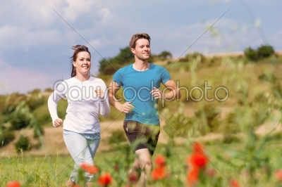 Young sportive couple is running outside