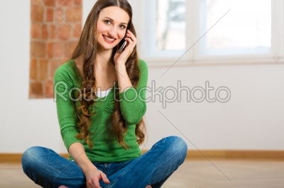 Young woman at home on the phone