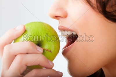 Young woman bites in a fresh and healthy apple