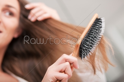 Young woman brushing her hair 