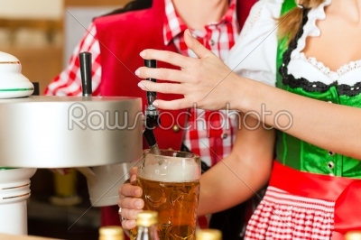 Young woman drawing beer in restaurant or pub