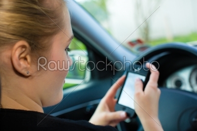 Young woman, in car with mobile phone 