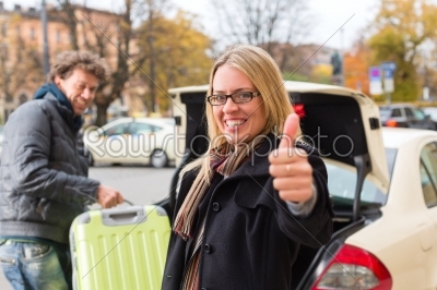 Young woman in front of taxi