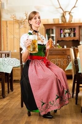 Young woman in traditional Bavarian Tracht in restaurant or pub