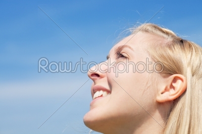 Young woman is looking into sky