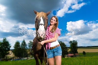 Young woman on the meadow with horse
