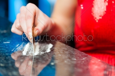 Young woman snorting cocaine in club or bar