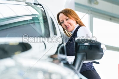 Young woman with auto in car dealership