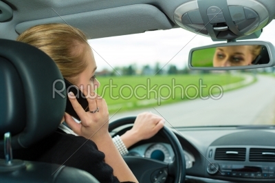 Young woman with telephone in car