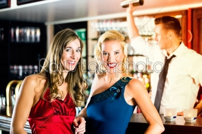 Young women and bartender in club or Bar
