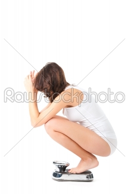 stock photo: young woman sitting on her haunches on a scale-Raw Stock Photo ID: 43858