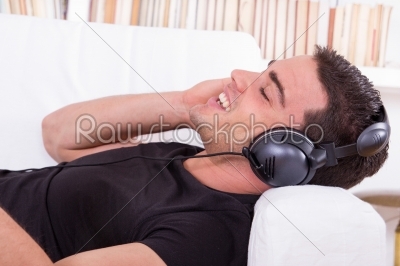 stock photo: handsome man resting on couch listening to music with headphones-Raw Stock Photo ID: 53556