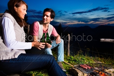 Alps - Couple at campfire in mountains