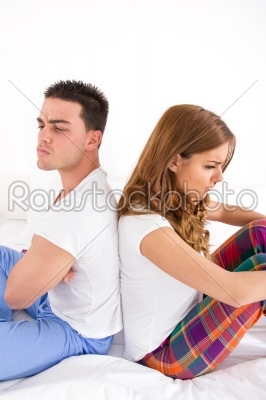 angry couple turning their back on each other in bed