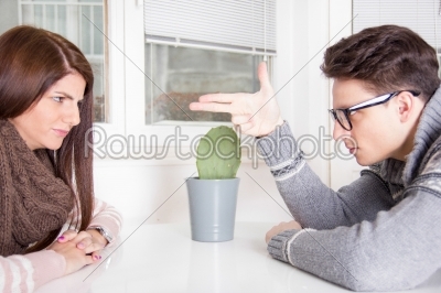angry man pointing at woman sitting across the table