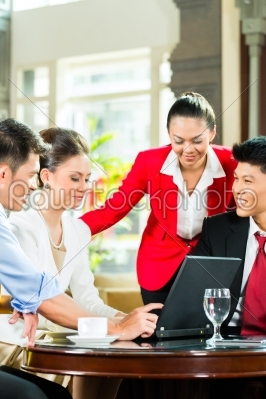 Asian business people at meeting in hotel lobby