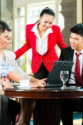 Asian business people meeting in hotel lobby
