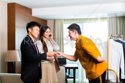 Asian Chinese bell boy or porter receiving tip 