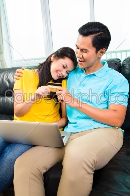 Asian couple online shopping with credit card
