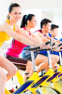 Asian people spinning bike training at fitness gym