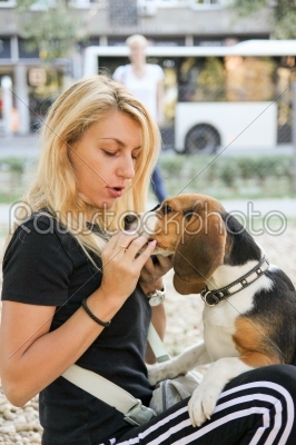 beautiful woman holding and feeding beagle puppy dog