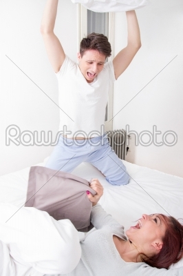 boy in pajamas hitting girl with pillow