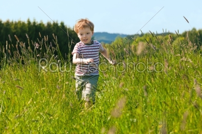 Boy running down a meadow