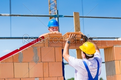 Bricklayer or builders on construction site working