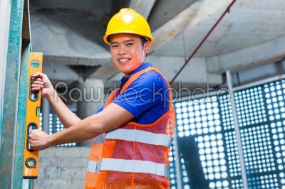 Builder or worker controlling wall on construction site