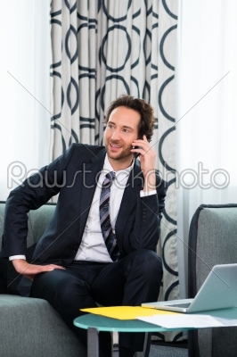 businessman in business hotel is on phone