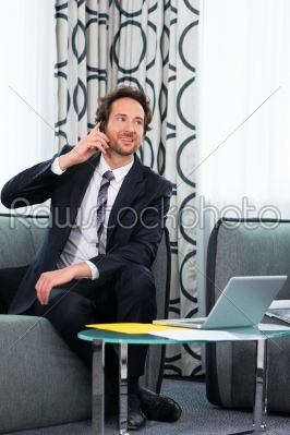 businessman in business hotel is on phone