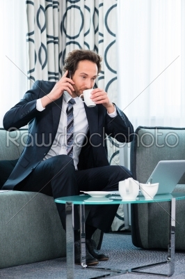 businessman in business hotel is on the phone