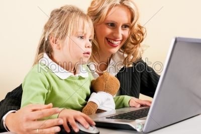 Businesswoman and mother showing kid the internet