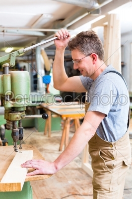 Carpenter using electric drill in carpentry