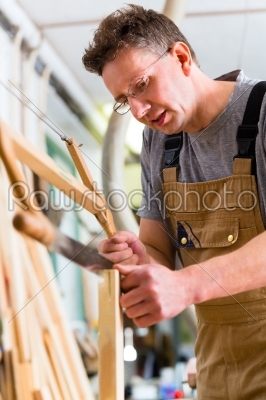 Carpenter using hand saw