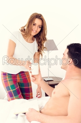 caucasian woman carrying coffee to her boyfriend in bed