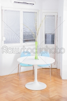central table with flower in front of windows