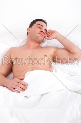 cheerful half naked man waking up in the bedroom