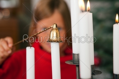 Child extinguishing Christmas candles