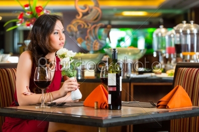 Chinese woman waiting in restaurant for date 