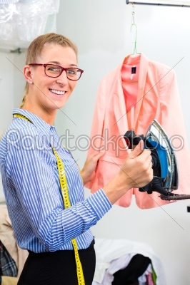 Cleaner in laundry shop ironing jacket 