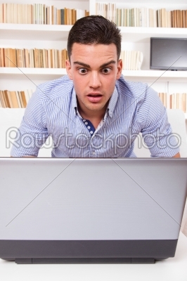 concerned man looking at computer monitor shocked