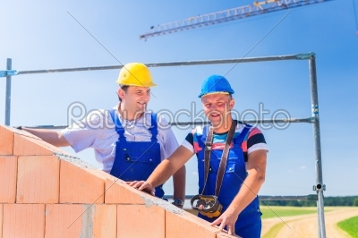 Construction site workers building house with crane