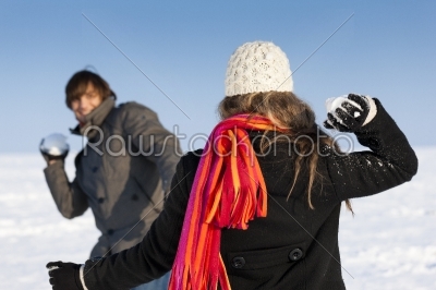 Couple having a snowball fight in winter