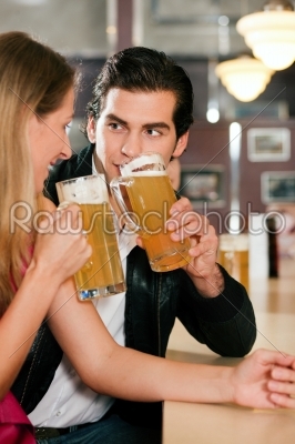 Couple in bar drinking beer flirting 