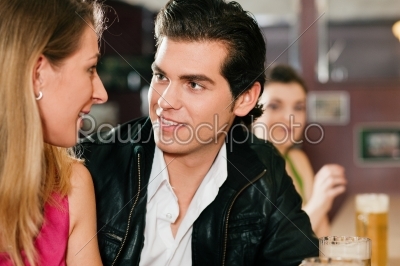 Couple in bar drinking beer flirting 