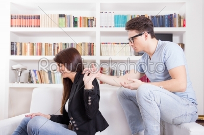 couple in conflict arguing at home holding hands